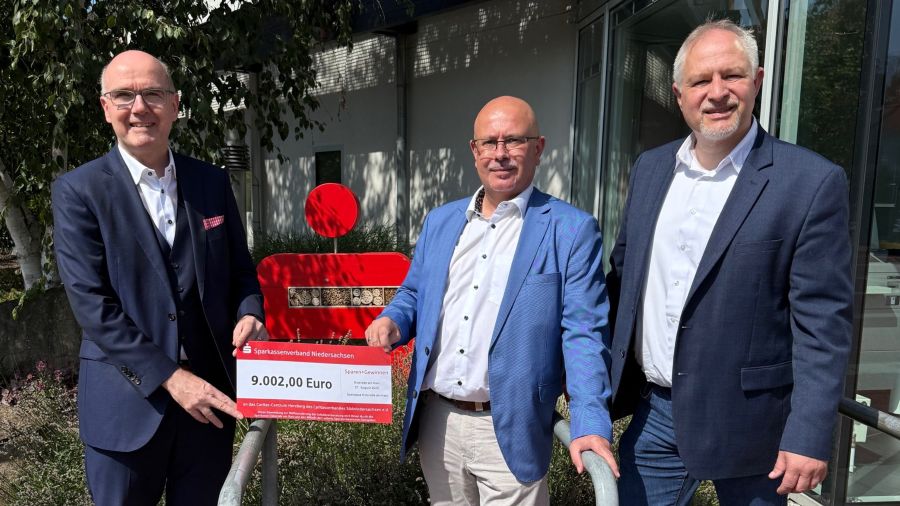 Das Foto zeigt die Scheckübergabe vor dem Gebäude der Sparkasse in Osterode am Harz.