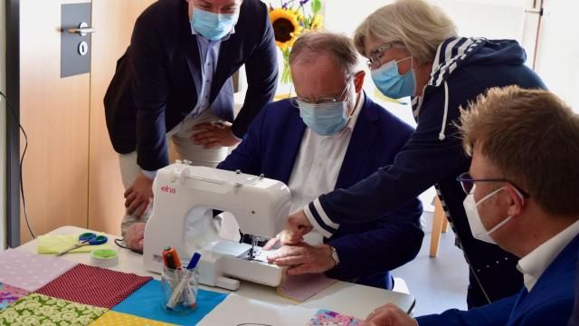 Stephan Weil näht unter Anleitung von Bärbel Schneegans.
