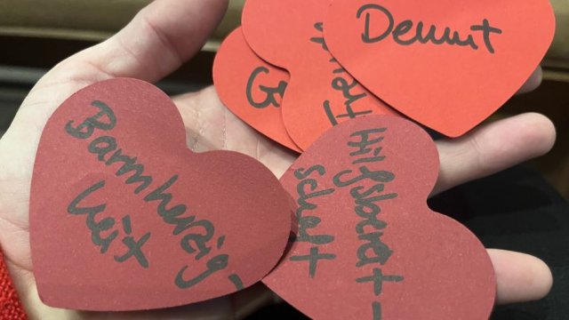 Das Foto zeigt rote Papierherzen mit Begriffen drauf.